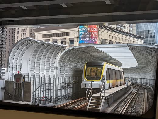 Tren del metro de Taipéi saliendo de un túnel entre edificios