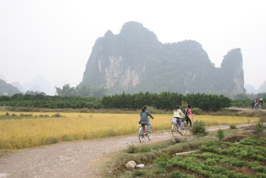Ciclistas por un camino de tierra entre picos kársticos