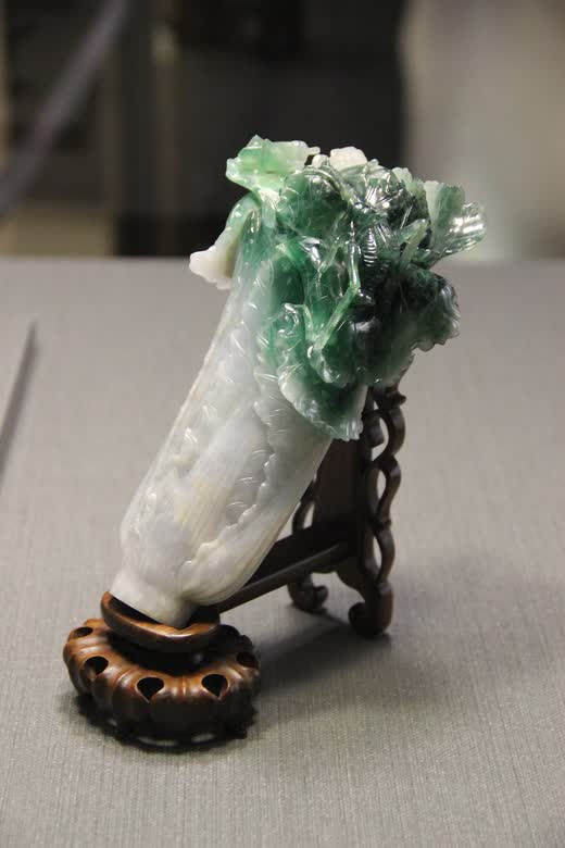 El repollo de jade tallado, sobre su peana de madera, en una vitrina