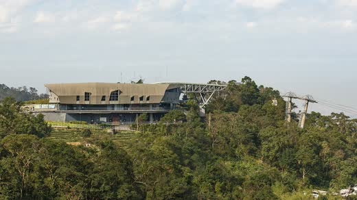 Estación del teleférico de Maokong sobre la ladera boscosa, con el cable saliendo hacia el valle