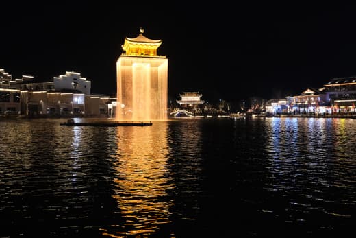 Torre iluminada sobre el lago de Wunvzhou de noche