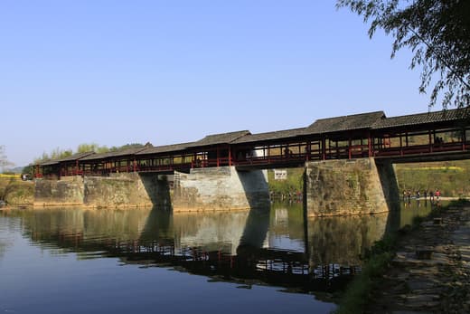 Puente cubierto del Arcoíris reflejado en el río