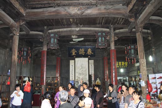 Interior de un salón ancestral de madera con gente