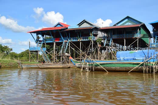 Casas de colores sobre pilotes altos junto al agua, con barcas amarradas