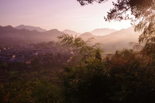 Xidi al amanecer con niebla en el valle
