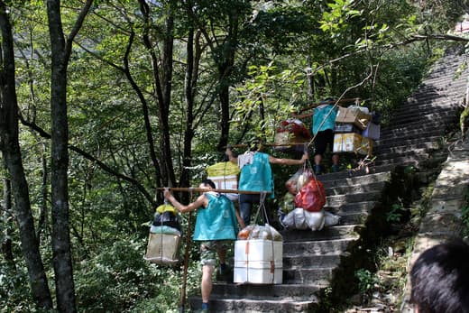 Porteadores subiendo cargas por las escaleras de Huangshan