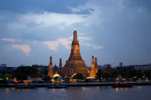Wat Arun iluminado al anochecer, visto desde el otro lado del río