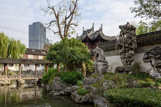 Rocalla y estanque del jardín Yuyuan con rascacielos al fondo