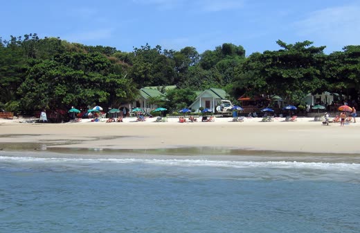 Playa de Ao Phai vista desde el agua, con sombrillas y bungalós
