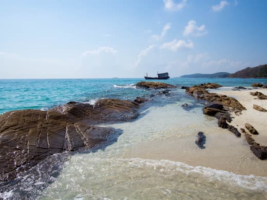 Rocas oscuras y agua turquesa transparente en la orilla