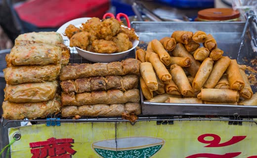 Puesto callejero con rollitos y fritos en bandejas